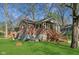 Brick home with chimney, side porch and partially exposed basement surrounded by a green lawn and mature trees at 7002 N Ralston Ave, Indianapolis, IN 46220