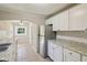 A bright kitchen features stainless appliances, granite counters, and traditional style white cabinetry at 7002 N Ralston Ave, Indianapolis, IN 46220