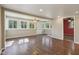 Sun-filled living room with wood floors, multiple windows, ceiling fan and white painted wall paneling at 7002 N Ralston Ave, Indianapolis, IN 46220