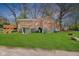 Brick home with a lush green yard and wooden deck, offering a serene outdoor retreat at 7002 N Ralston Ave, Indianapolis, IN 46220
