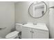 Bathroom featuring a modern white vanity, updated fixtures, and a round mirror detail at 717 S A St, Elwood, IN 46036