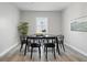 Dining room with black table and chairs, wood-look floors, and a large window at 717 S A St, Elwood, IN 46036