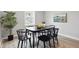 Dining room with black table and chairs, wood-look floors, a large window and decorative plant at 717 S A St, Elwood, IN 46036