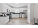 Bright kitchen features white cabinets, stainless steel appliances, black countertops, and wood-look floors at 717 S A St, Elwood, IN 46036