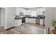Bright kitchen features white cabinets, stainless steel appliances, black countertops, and wood-look floors at 717 S A St, Elwood, IN 46036