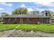 Backyard view of a brick home with a sliding glass door and a lawn that is in need of some landscaping at 7412 Hiner Ln, Indianapolis, IN 46219