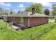 Backyard view of brick home with a sliding glass door, a well-kept lawn and a partial view of the chain link fence at 7412 Hiner Ln, Indianapolis, IN 46219
