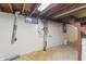 Unfinished basement with exposed plumbing and a small window, offering potential for customization at 7412 Hiner Ln, Indianapolis, IN 46219