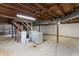 Unfinished basement with utilities, exposed ceiling, and a staircase to the upper level at 7412 Hiner Ln, Indianapolis, IN 46219