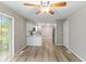 Dining area with sliding door, fan, hardwood flooring, and view of kitchen with stainless steel refrigerator at 7412 Hiner Ln, Indianapolis, IN 46219