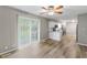 Open floorplan with hardwood flooring and view of the kitchen and outdoor space via sliding door at 7412 Hiner Ln, Indianapolis, IN 46219