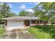 Charming single-story brick home with attached garage, well-maintained lawn, and classic architectural details at 7412 Hiner Ln, Indianapolis, IN 46219