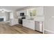 Bright kitchen features white cabinets, stainless steel appliances, modern countertops, and hardwood flooring at 7412 Hiner Ln, Indianapolis, IN 46219