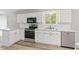 Well-lit kitchen with stainless steel appliances, white subway tile backsplash, updated fixtures and hardwood flooring at 7412 Hiner Ln, Indianapolis, IN 46219