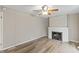 Cozy living room area with a traditional fireplace, fan, hardwood flooring, and neutral paint colors at 7412 Hiner Ln, Indianapolis, IN 46219
