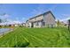 Home's backyard with a pond view, lush green lawn, and covered patio at 745 S Summerhaven Ct, New Palestine, IN 46163