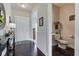 Foyer with hardwood flooring leading to a half bathroom; decorated with mirror and table at 745 S Summerhaven Ct, New Palestine, IN 46163
