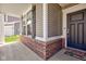 Welcoming front porch with brick accents, siding, and a stylish black front door at 745 S Summerhaven Ct, New Palestine, IN 46163