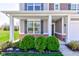 Inviting front porch showcasing classic architecture with decorative columns, lush landscaping, and brick accents at 745 S Summerhaven Ct, New Palestine, IN 46163