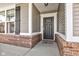 Close-up of front door with brick accents and stylish siding, creating a warm entrance at 745 S Summerhaven Ct, New Palestine, IN 46163