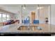 Granite countertop island with stainless sink overlooks open floorplan, connecting kitchen, dining, and living spaces at 745 S Summerhaven Ct, New Palestine, IN 46163