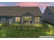 Dusk view of the fenced backyard with covered patio, outdoor furniture, and lush lawn at 75 Hovden Dr, Cicero, IN 46034