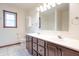 Bathroom boasts double sinks, a large mirror, a window, and white tiled floors at 801 Echo Trl, Martinsville, IN 46151