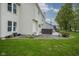 Backyard view of the house, hot tub, and patio with green grass and some landscaping at 8875 White Fir Dr, Indianapolis, IN 46256