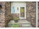 Close-up of a charming front porch with brick, decorative wreath, and potted flowers at 8875 White Fir Dr, Indianapolis, IN 46256