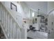 Bright living room featuring high ceilings, a ceiling fan, a bookshelf, and a staircase at 8875 White Fir Dr, Indianapolis, IN 46256