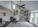 Bright living room featuring high ceilings, a ceiling fan, a bookshelf, and a large window at 8875 White Fir Dr, Indianapolis, IN 46256