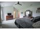 Carpeted main bedroom with a fan, dresser, and access to the attached bathroom at 8875 White Fir Dr, Indianapolis, IN 46256