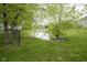 Backyard pond surrounded by lush green grass and mature trees along the fence at 8875 White Fir Dr, Indianapolis, IN 46256