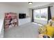 Bright bedroom featuring a large window, TV, and dollhouse at 900 Parker Ln, Westfield, IN 46074