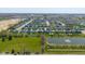 Extensive aerial shot showcasing a residential community, pond, and green fields at 900 Parker Ln, Westfield, IN 46074