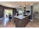Open-concept kitchen with island seating, pendant lights, and view of the dining and living areas at 900 Parker Ln, Westfield, IN 46074