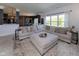 Bright and airy living room with large sectional, ottoman, and view of the backyard at 900 Parker Ln, Westfield, IN 46074
