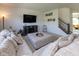 This living room features a large sectional couch, fireplace, entertainment center, and stairs to the upper level at 900 Parker Ln, Westfield, IN 46074