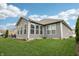 A pleasant backyard view showcases a green lawn, enclosed sunroom, and landscaped garden at 9359 Foudray N Cir, Avon, IN 46123