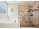 Bright bathroom features a soaking tub and glass enclosed shower with a tiled surround and shower niche at 9359 Foudray N Cir, Avon, IN 46123