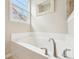 Relaxing bathroom features a deep soaking tub with tile surround, large windows and a decorative mirror at 9359 Foudray N Cir, Avon, IN 46123