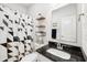 Modern bathroom with black and white shower curtain, black granite counter, and wall shelves at 9359 Foudray N Cir, Avon, IN 46123