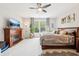 Spacious bedroom with a fireplace, plush carpet, a ceiling fan, and large window, offering comfort and style at 9359 Foudray N Cir, Avon, IN 46123