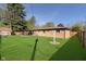 Spacious backyard features a sunroom, a shed, mature trees, and a well-kept lawn at 9748 W Sunset Ln, Elwood, IN 46036