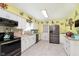 Bright eat-in kitchen features stainless steel appliances, white cabinets, and tile backsplash at 9748 W Sunset Ln, Elwood, IN 46036