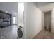 Hallway with stacked washer and dryer in hall, leading to living room and bathroom at 102 Clarendon Dr # 506, Noblesville, IN 46062