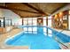 Indoor pool area with wood paneled walls and vaulted ceiling, and large windows overlooking a lake at 102 Clarendon Dr # 506, Noblesville, IN 46062