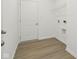 Bright laundry room featuring vinyl floors, white walls, and a storage shelf above hookups at 10250 Camp Creek Way, Indianapolis, IN 46229