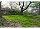 A wide shot of backyard featuring house exterior, mature tree, and lawn at 112 Coronado Rd, Indianapolis, IN 46234