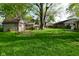 A backyard featuring green grass, mature trees and a detached garage at 112 Coronado Rd, Indianapolis, IN 46234